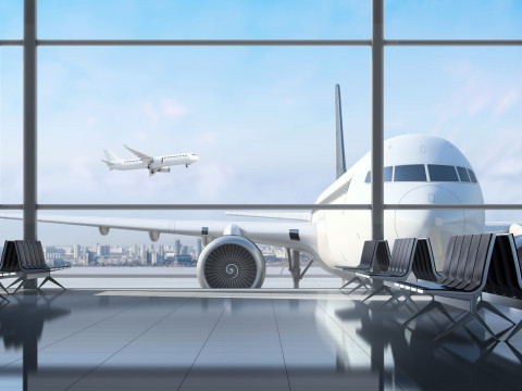 looking out of an airport at a grounded plane and a plane in the sky